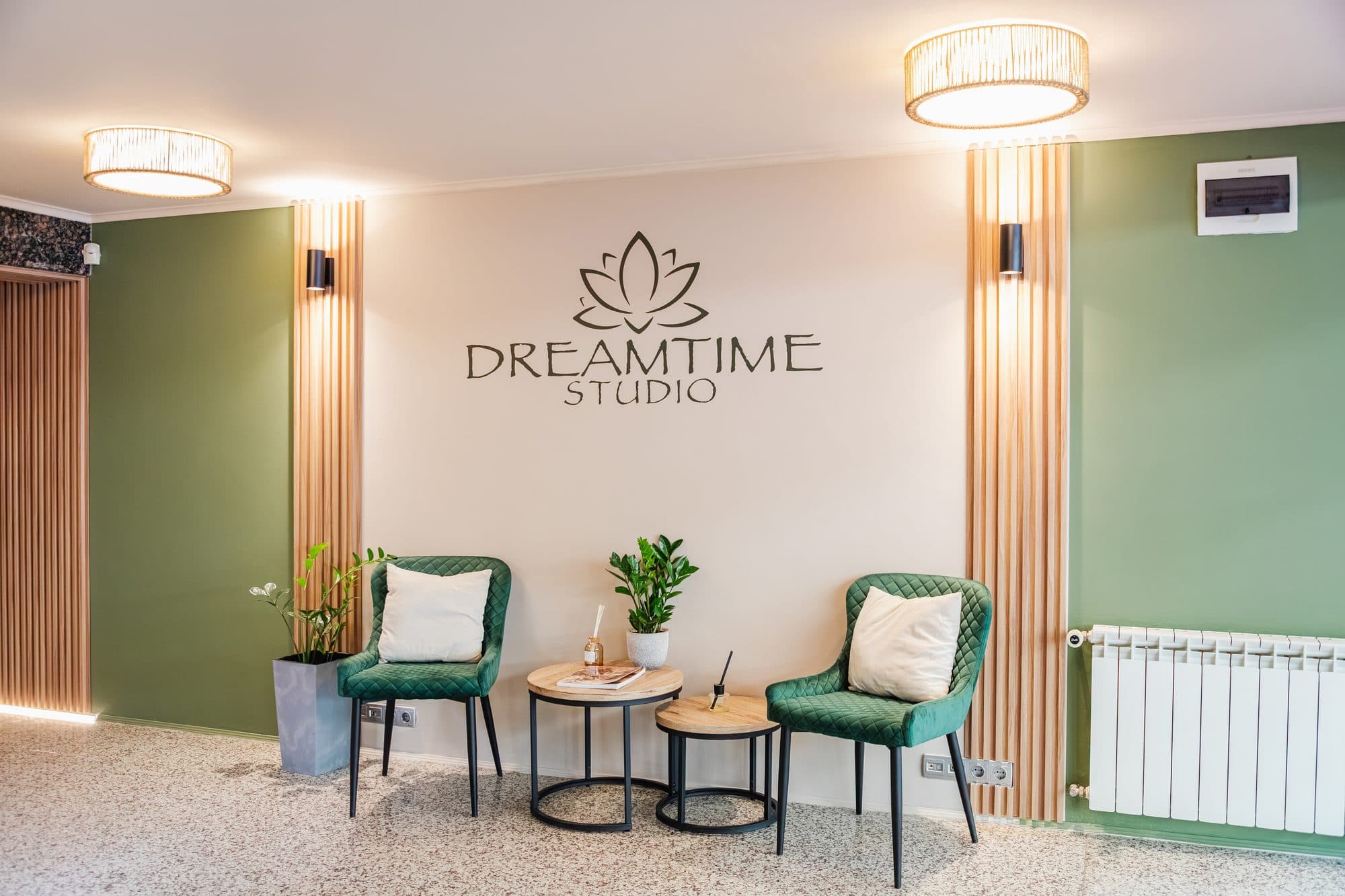 Чакалнята на DreamTime Studio в Лозенец: две зелени кресла, масички и логото на стената